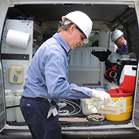 Man testing the quality of water in the field at a van