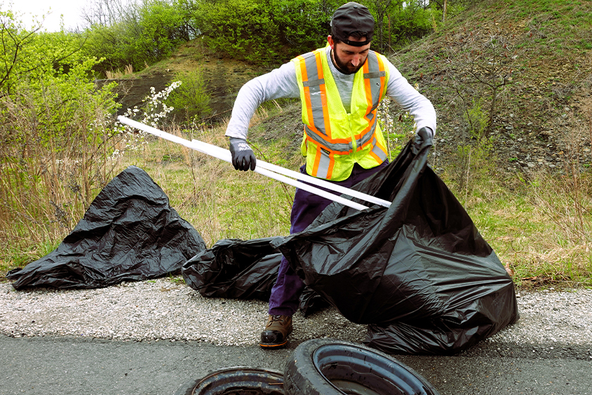 ALCOSAN employee picking up litter